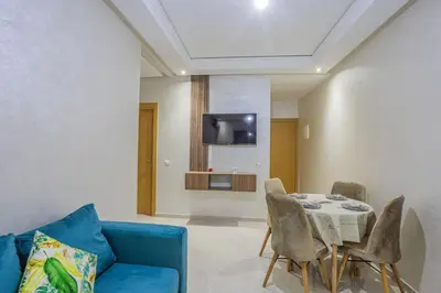 a living room with a blue couch and a table at Family apartment Jardins Chrifia in Marrakech