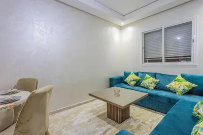 a living room with a blue couch and a table at Family apartment Jardins Chrifia in Marrakech
