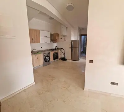 an empty kitchen with a washer and dryer at Appartement moderne confortable 2 chambres près de Marrakech Gueliz piscine in Marrakech