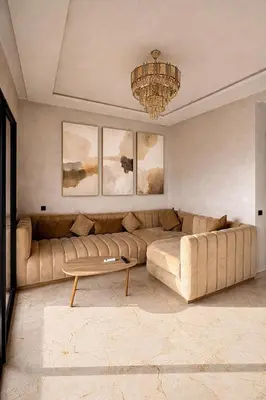 a living room with a large couch and a chandelier at Appartement moderne confortable 2 chambres près de Marrakech Gueliz piscine in Marrakech