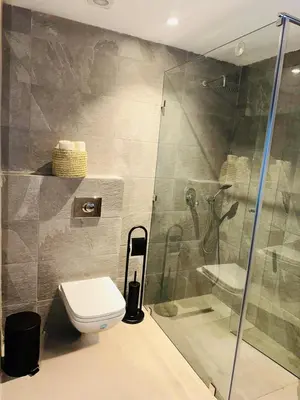 a bathroom with a toilet and a glass shower at Appartement Cozy Hivernage in Marrakech