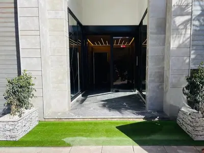 an entrance to a building with green grass in front at Appartement Cozy Hivernage in Marrakech