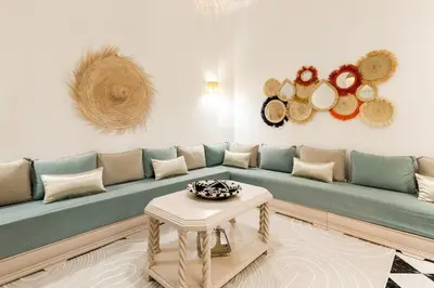 a living room with a blue couch and a table at Riad Qarya Petit-déjeuner et transfert inclus in Marrakech