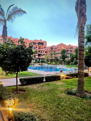 a resort with a swimming pool and a palm tree at Quite place for your vacation in Marrakech