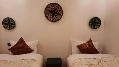 two beds in a room with plates on the wall at Hotel & Riad Celia in Marrakech