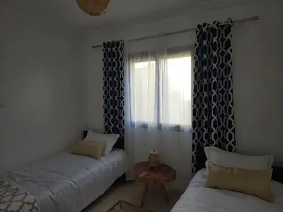 a bedroom with two beds and a window at Quiet and comfortable apartment in Marrakech