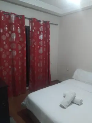 a bedroom with a bed with red curtains at chambre Economic Gueliz in Marrakech