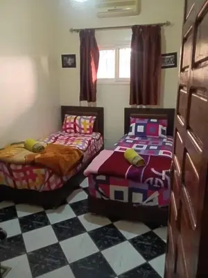 two beds in a room with a checkered floor at Appartement Chez Anita in Marrakech