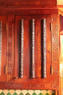 a wooden cabinet with a bunch of books in it at la roseraie Marrakech in Marrakech