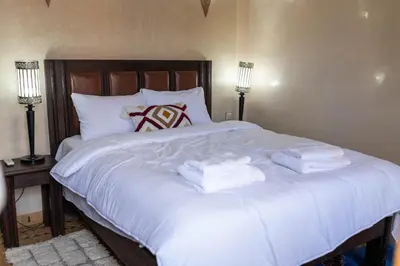 a large white bed with two folded towels on it at la roseraie Marrakech in Marrakech