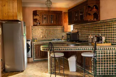 a kitchen with a refrigerator and some bar stools at la roseraie Marrakech in Marrakech