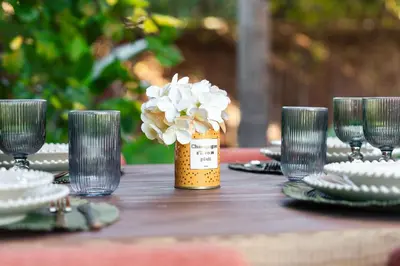a table with glasses and a jar with flowers in it at Oasis Privée - Dar Lola in Marrakech