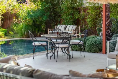a patio with a table and chairs next to a pool at Oasis Privée - Dar Lola in Marrakech