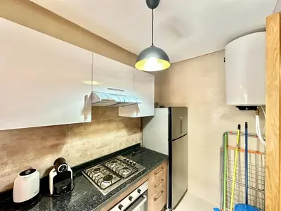a kitchen with white cabinets and a black counter top at Comfy Luxe Stay Golf View Marrakech in Marrakech