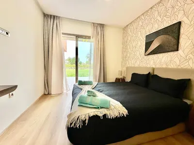 a bedroom with a black bed with a rug on it at Comfy Luxe Stay Golf View Marrakech in Marrakech