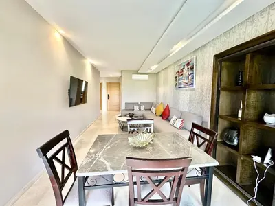 a dining room with a table and a couch at Comfy Luxe Stay Golf View Marrakech in Marrakech