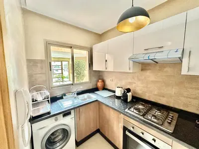 a kitchen with a sink and a washing machine at Comfy Luxe Stay Golf View Marrakech in Marrakech