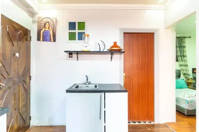 a kitchen with a sink and a room with a bed at Lely appartement 2min de là garé in Marrakech