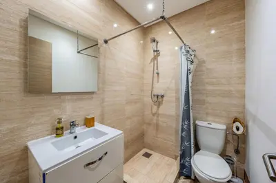 a bathroom with a shower and a toilet and a sink at Magnifique appartement rez-de-jardin face piscine in Marrakech