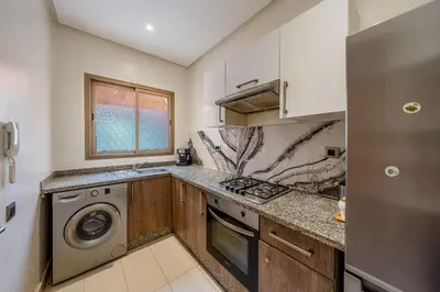a kitchen with a washer and dryer in it at Magnifique appartement rez-de-jardin face piscine in Marrakech