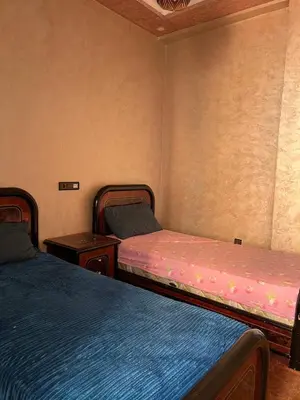 a room with two beds and two night stands at Modern Apartment 5 Min from Airport & Secure in Marrakech