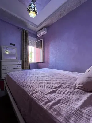 a bedroom with a large bed and a window at Modern Apartment 5 Min from Airport & Secure in Marrakech