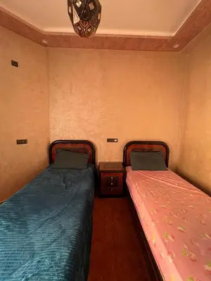 two beds sitting next to each other in a room at Modern Apartment 5 Min from Airport & Secure in Marrakech