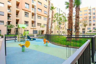 a playground in a apartment complex with palm trees at Inside A Mood - Marrakech in Marrakech