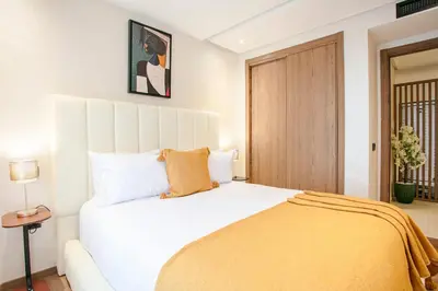 a bedroom with a large white bed with a yellow blanket at Inside A Mood - Marrakech in Marrakech