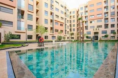 a person sitting in a chair in front of a swimming pool at Inside A Mood - Marrakech in Marrakech