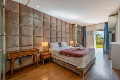 a bedroom with a large stone wall and a bed at Prestigia Agate Appartement luxueux Marrakech golf city in Marrakech