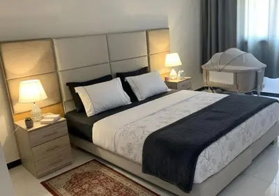 a bedroom with a large bed with two night stands and two lamps at Appart zénith in Marrakech