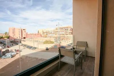 a balcony with a chair and a view of a city at Good Vibes - Hivernage Marrakech in Marrakech