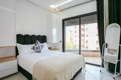 a bedroom with a large bed and a large window at The Right Address - Hivernage Marrakech in Marrakech