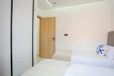 two beds in a small room with a door at The Right Address - Hivernage Marrakech in Marrakech