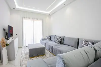 a living room with a gray couch and a table at The Right Address - Hivernage Marrakech in Marrakech