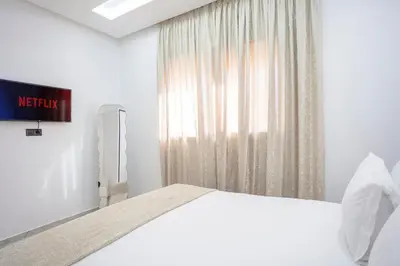 a white bedroom with a bed and a window at The Cozy Corner - Hivernage Marrakech in Marrakech