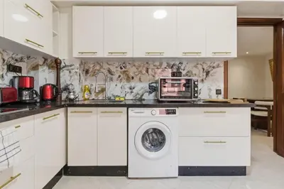 a kitchen with white cabinets and a washer and dryer at Cosy 2BR Appartment, in City Center, AC, Iptv in Marrakech