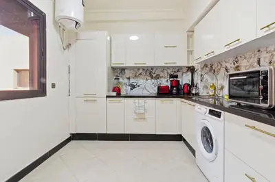 a kitchen with white cabinets and a washer and dryer at Cosy 2BR Appartment, in City Center, AC, Iptv in Marrakech