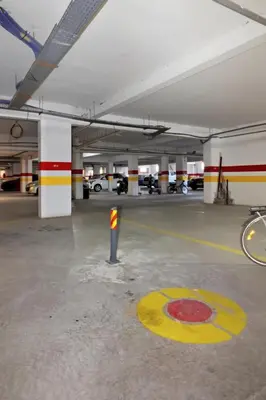 a parking garage with a parking lot with cars at Cosy 2BR Appartment, in City Center, AC, Iptv in Marrakech