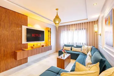 a living room with a blue couch and a tv at NEW Guéliz I Blue Mirage I Crafts and modernity in Marrakech