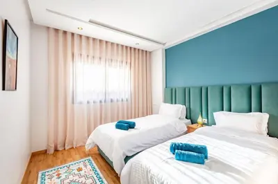a bedroom with two beds and a window at NEW Guéliz I Blue Mirage I Crafts and modernity in Marrakech
