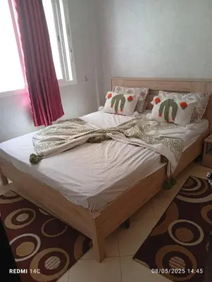 a bed with white sheets and pillows in a bedroom at Appartement Marrakchi in Marrakech