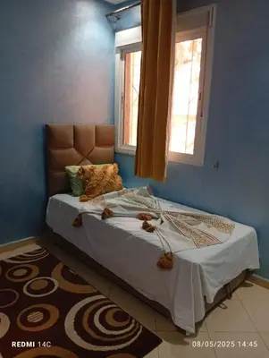 a bed in a bedroom with a blue wall at Appartement Marrakchi in Marrakech