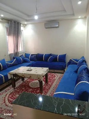a living room with blue couches and a table at Appartement Marrakchi in Marrakech