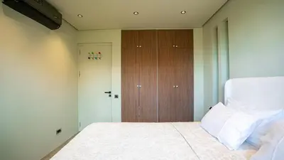 a bedroom with a bed and a wooden closet at Suites 25, Hivernage, Calme, 2BR, Marrakech in Marrakech