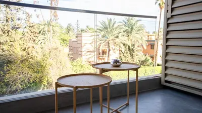 a table and two chairs in front of a window at Suites 25, Hivernage, Calme, 2BR, Marrakech in Marrakech