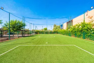 a tennis court with a net on top of it at Appartement KENZ Nouria avec piscine in Marrakech