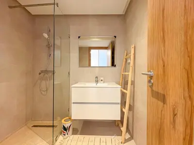 a bathroom with a sink and a glass shower at Appartement KENZ Nouria avec piscine in Marrakech