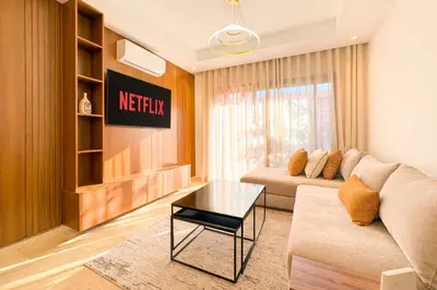a living room with a couch and a table at Appartement KENZ Nouria avec piscine in Marrakech